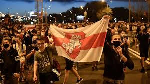 Belarusian protestors carry the banned white-red-white flag.